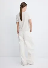 Camiseta de lino color blanco, con cuello en V y mangas cortas, de corte recto y clásico.