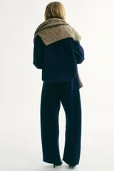 Jean de denim rígido azul oscuro, con corte holgado y diseño curvo en las piernas. Presenta cintura estándar con cordón ajustable, cierre con botón y bolsillos clásicos.