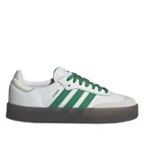 Championes Adidas modelo Sambae, con diseño de plataforma en color marrón translúcido. Presenta una base de cuero blanco con las icónicas tres rayas laterales en color verde, cordones verdes a juego y detalles de costuras decorativas en el talón.