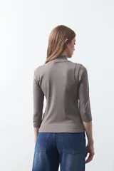 Polera de algodón color blanco, con cuello alto y mangas tres cuartos. Presenta un diseño ajustado al cuerpo con costuras decorativas en las sisas.