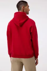 Canguro de corte holgado confeccionado en mezcla de algodón de peso medio con interior cepillado suave. Presenta capucha forrada con cordón de ajuste, hombros caídos, bolsillo tipo canguro frontal y terminaciones acanaladas en puños y bajo.