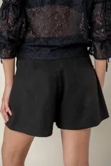 Pollera pantalón de corte recto y diseño minimalista, con cierre lateral y detalle de bolsillo tipo ojal en la parte frontal.