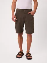 Bermuda de lona color verde militar, corte carpenter fit con bolsillos laterales y presillas para cinturón.