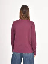 Remera de manga larga con cuello redondo, confeccionada en tejido de punto liso.