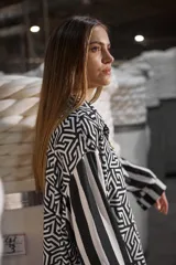 Camisa holgada estampada en blanco y negro, con cuello solapa, mangas largas con puños abotonados y cierre frontal con botones.