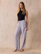 Pantalón de lino con rayas verticales en tonos beige, azul y gris. Tiene pretina elastizada, bolsillos inclinados en la parte delantera y un bolsillo tipo cargo en el lateral. Marca Zac & Rachel.