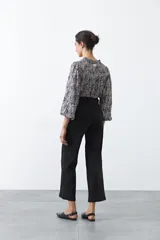 Jean wide leg de color negro, con costuras frontales verticales que estilizan la silueta y cierre frontal con botón metálico.