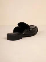 Zuecos negros de símil cuero con tachas en la capellada, taco de 3cm y suela acolchonada.