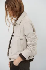 Chaqueta de pana color azul oscuro, con cuello camisero, cierre frontal con botones y bolsillos laterales. Diseño de corte recto y manga larga.
