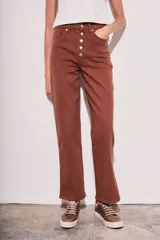Pantalón de jean color marrón, de corte recto y tiro medio, con cierre frontal con botones.