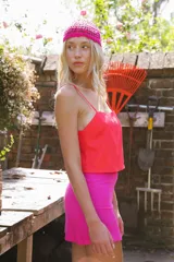 Minifalda rosa confeccionada en lino y rayón, de tiro medio alto y corte recto.