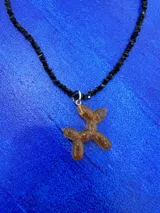 Collar corto de cuentas negras facetadas con dije de perro salchicha tipo globo en resina color ámbar con destellos brillantes.