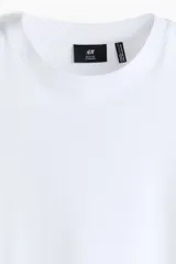 Remera blanca de manga corta, confeccionada en punto liviano con cuello redondo ribeteado y bajo recto, de corte estándar y silueta clásica.