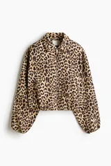 Campera oversized de sarga con estampado de leopardo, cuello camisero, cierre frontal, bolsillos laterales ribeteados y puños elásticos.