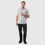 Camisa de manga corta con cuello clásico, cierre frontal de botones y un bolsillo en el pecho. Presenta un diseño de corte regular con textura natural.