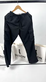 Pantalón cargo de nylon negro, corte holgado con bolsillos laterales con solapa y cintura elástica ajustable con cordón.