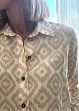 Camisa de fibrana de estilo clásico con estampa ikat en tonos beige y blanco, cuello camisero y botones oscuros.