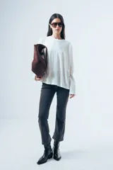 Remera de manga larga con corte oversize, confeccionada en algodón de color blanco, con cuello redondo y diseño minimalista.