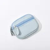 Monedero pequeño celeste de cuero sintético con cierre superior.