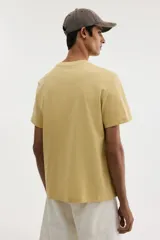Remera de algodón de corte estándar, con cuello redondo y mangas cortas, en color mostaza.