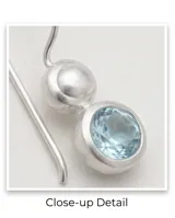 Aros colgantes de plata 925 con diseño articulado que presenta una perla esférica en la parte superior y una circonia redonda facetada de color celeste en el extremo inferior.