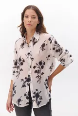 Camisa de mujer color natural con estampado floral en tonos oscuros, cuello clásico, cierre de botones frontal y mangas largas.