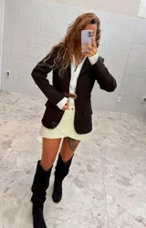 Blazer de largo medio con diseño de frente abierto, cierre mediante un cinturón de cuero fino incorporado a la cintura, bolsillos con solapa y mangas largas.