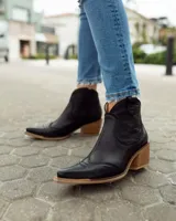Bota texana de caña baja color marrón con efecto vintage, confeccionada en cuero vacuno y forrada en cuero. Tiene taco de 5cm y cierre lateral.