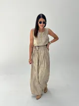 Conjunto de musculosa y pantalón palazzo color dorado brillante. La musculosa es sin mangas y el pantalón es de corte ancho con cintura alta.