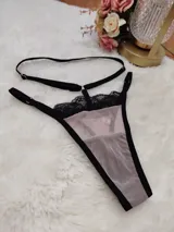 Tanga de microtul color tostado con detalles de encaje negro en la parte superior y tiras elásticas regulables.