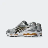 Championes Asics Gel Kayano 14 en color plateado con detalles en negro y dorado, de estilo retro inspirados en los años 2000, con capellada de malla y material sintético, y tecnología GEL en la suela.