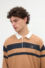Remera polo de manga larga con diseño de rayas horizontales rojas sobre fondo blanco, cuello camisero tostado con media cartera de botones y puños ajustados.