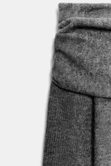 Jersey de punto gris con escote recto tipo palabra de honor, con detalle de vuelta en la parte superior y manga larga.