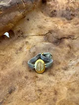 Pulsera elástica de terciopelo marrón con medalla ovalada dorada de la Virgen María.