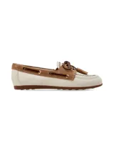Mocasín de cuero estilo náutico, en combinación de color crema y marrón gamuzado. Presenta detalles de costuras artesanales, cordones de cuero cruzados con ojales metálicos, flecos y borlas decorativas en el empeine.