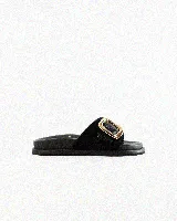 Sandalias de cuero color negro, de diseño plano con una tira ancha en el empeine y una hebilla metálica dorada grande como detalle.