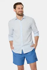 Short de baño azul vibrante, de corte clásico y largo medio, con cintura elástica y cordón ajustable. Cuenta con bolsillos laterales y suspensor de malla fina interior.