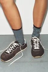 Zapatillas de estilo deportivo con diseño barefoot, confeccionadas en una combinación de materiales que incluye piel vacuno en la lengüeta. Presentan una puntera amplia, suela flexible con efecto engomado, plantilla Ortholite extraíble y cierre mediante cordones.