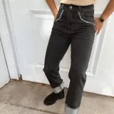 Pantalón jean de tiro alto en color azul oscuro, con bolsillos delanteros redondeados con detalles deshilachados.