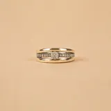 Anillo de diseño ancho compuesto por una banda central de oro pulido flanqueada por dos bandas laterales de plata con textura arenada. El segundo anillo es una alianza de plata y oro con una hilera central de circonias engastadas.
