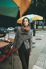 Chaqueta de tweed en tonos gris y negro, con cuello desmontable de pelo sintético marrón, bolsillos delanteros de plastrón y acabados deshilachados.