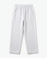 Pantalón deportivo baggy gris melange, de corte holgado, con cintura elástica, bolsillos laterales y líneas blancas laterales.