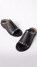Sandalias de cuero color marrón con detalles de tachas doradas.
