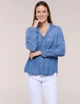 Camisa confeccionada en tela tencel azul, de estilo casual y silueta semi holgada. Presenta cuello camisero tradicional, abotonadura frontal completa, dos bolsillos superiores en el pecho y mangas largas con presilla y botón para arremangar.