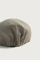 Boina con visera de color beige y marrón con diseño de cuadros pequeños, confeccionada en tejido con viscosa y ajuste elástico posterior.
