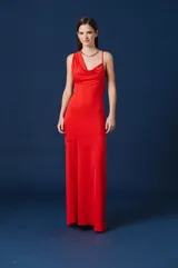 Vestido largo de color rojo, con escote drapeado y un solo bretel fino. Presenta un corte asimétrico en la cintura y una falda de caída fluida.