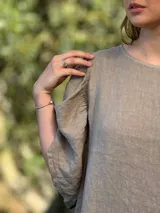 Vestido verde oliva de lino, corte suelto, con mangas abullonadas y volado en el ruedo.