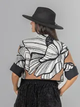 Sweater de tejido de punto con diseño estampado floral en tonos blanco, negro y tostado. Presenta cuello semi polera, mangas cortas hasta el codo con puños anchos y corte holgado.