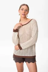 Sweater de tejido calado color crema con cuello bote y terminaciones en marrón.