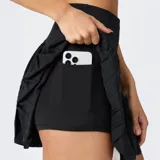 Minifalda plisada de tiro alto con shorts incorporados, confeccionada en tejido técnico transpirable. Presenta un diseño deportivo con cintura elástica ancha y bolsillos ocultos.